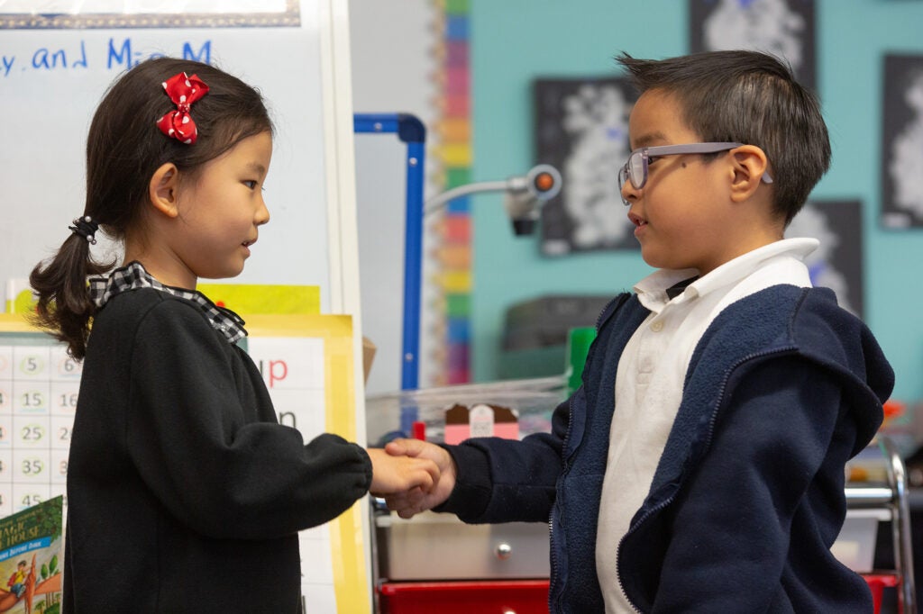 Two children hold hands