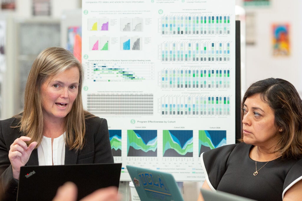 A woman presents her research while another looks on