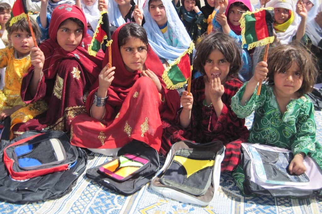 A group of Afghan girls hold up flags