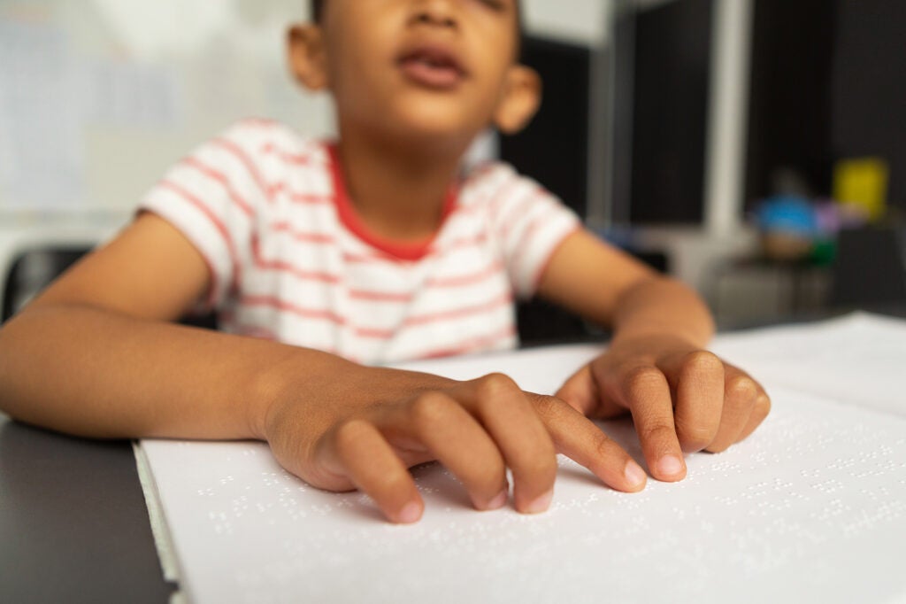 A boy reads a Braille book