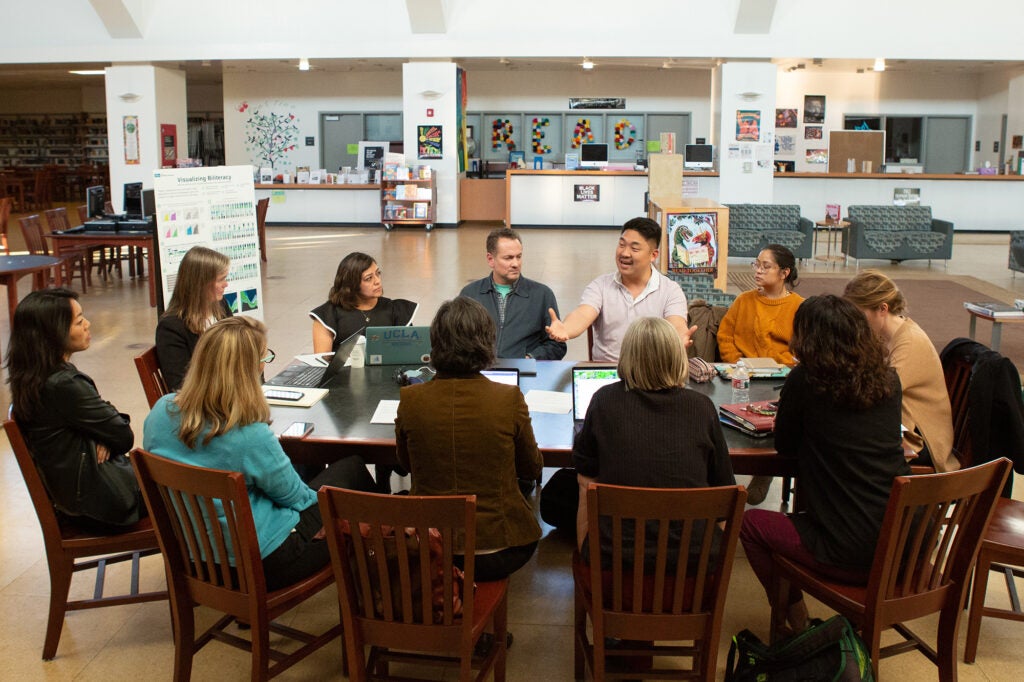 Educators sit around a table talking