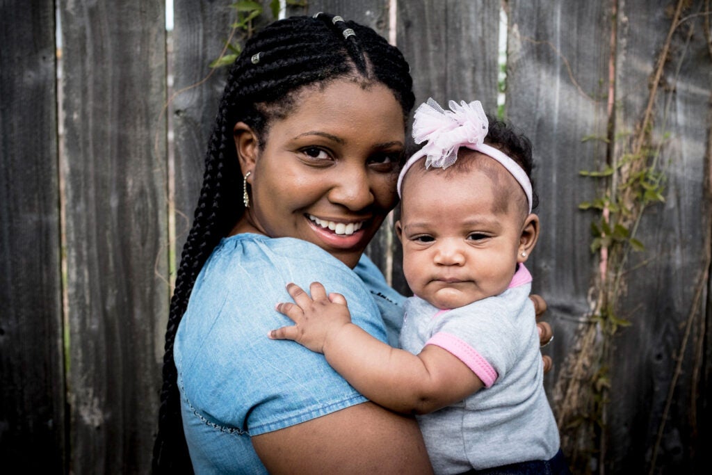 A Black mother holds her baby girl